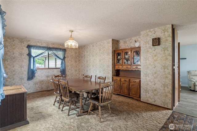 1826 156th St NE, Arlington, WA 98223 - dining room featuring wallpapered walls, a textured ceiling, light carpet, baseboards, and a chandelier