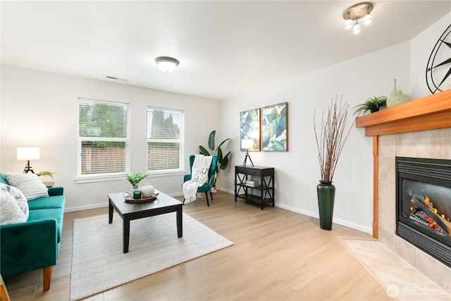 9402 187th St E, Puyallup, WA 98375 - living area featuring wood finished floors, a tiled fireplace, and baseboards