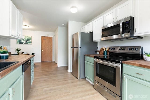 9402 187th St E, Puyallup, WA 98375 - kitchen featuring wood counters, appliances with stainless steel finishes, light wood-style flooring, green cabinetry, and white cabinets