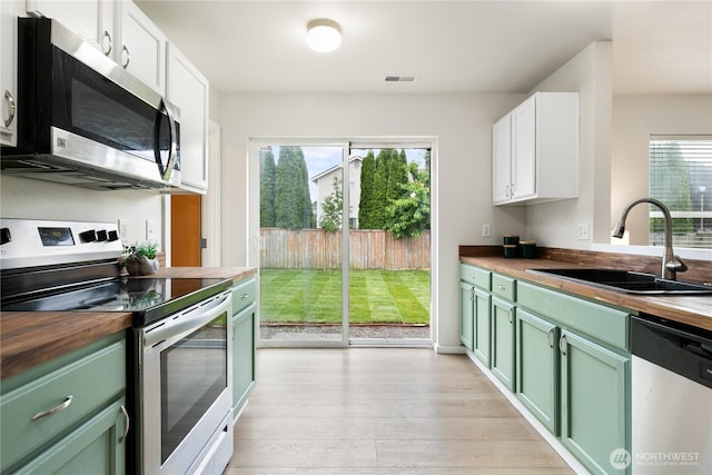 9402 187th St E, Puyallup, WA 98375 - kitchen with butcher block counters, stainless steel appliances, green cabinets, and a sink