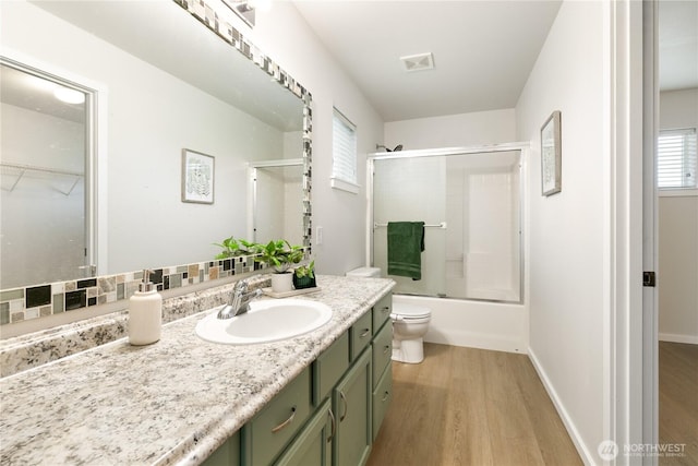9402 187th St E, Puyallup, WA 98375 - full bathroom with wood finished floors, vanity, toilet, combined bath / shower with glass door, and healthy amount of natural light