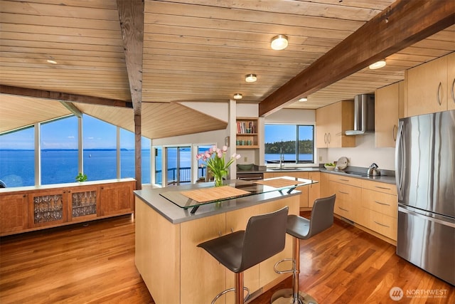 161 Montgomery Ln, Port Ludlow, WA 98365 - kitchen with freestanding refrigerator, wall chimney exhaust hood, light brown cabinetry, wood ceiling with exposed beams, and a center island