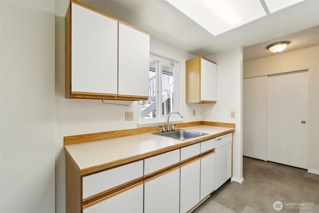kitchen with a sink, dishwasher, light countertops, and white cabinets