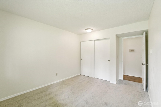 unfurnished bedroom with carpet, a closet, and baseboards