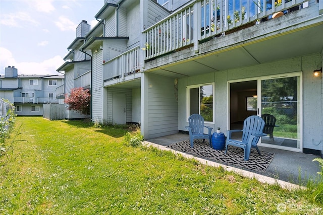 view of green lawn with a patio and a balcony
