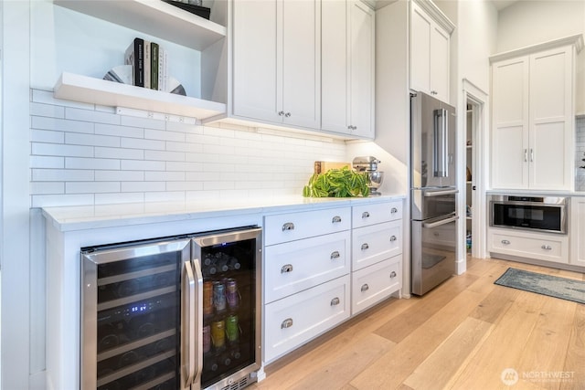 53 Daybreak Rd, Walla Walla, WA 99362 - kitchen featuring beverage cooler, appliances with stainless steel finishes, light countertops, light wood finished floors, and decorative backsplash