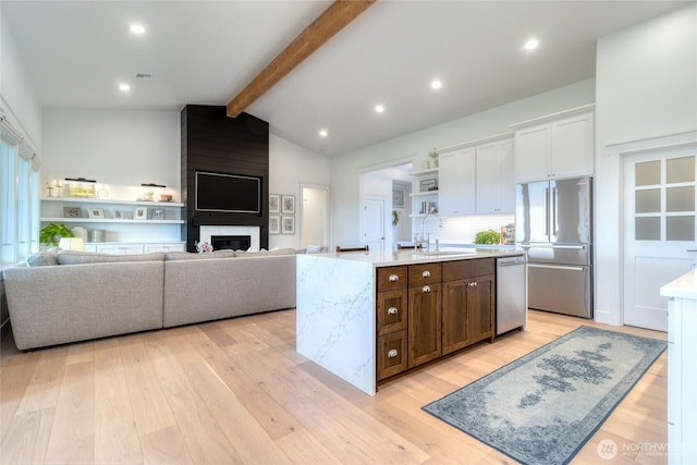 53 Daybreak Rd, Walla Walla, WA 99362 - kitchen featuring stainless steel appliances, light wood-type flooring, white cabinets, an island with sink, and backsplash
