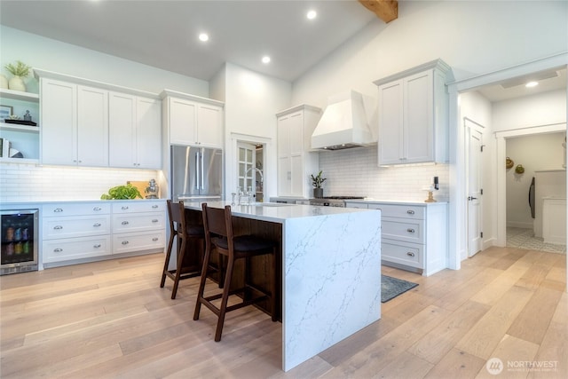 53 Daybreak Rd, Walla Walla, WA 99362 - kitchen with beverage cooler, custom exhaust hood, appliances with stainless steel finishes, a sink, and a breakfast bar