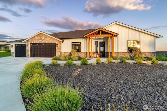 53 Daybreak Rd, Walla Walla, WA 99362 - view of front of home with stone siding, a garage, board and batten siding, and driveway