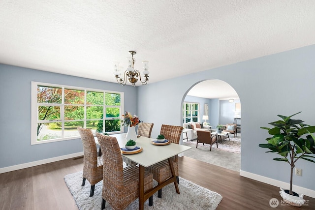 12043 184th Ave NE, Redmond, WA 98052 - dining area with arched walkways, a chandelier, wood finished floors, and a textured ceiling