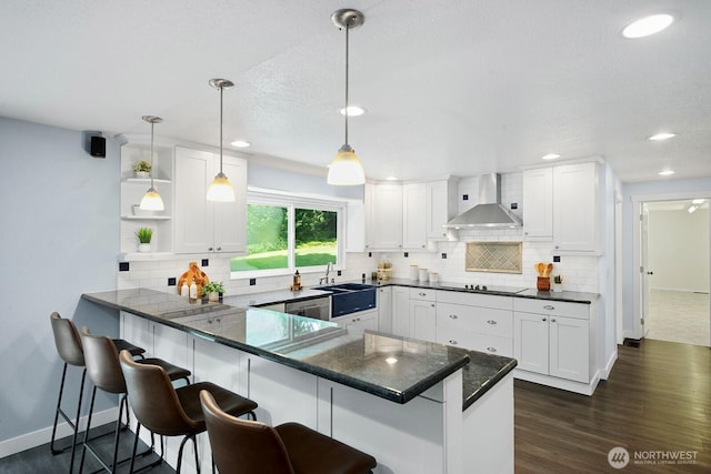 12043 184th Ave NE, Redmond, WA 98052 - kitchen with wall chimney range hood, white cabinetry, a peninsula, a breakfast bar area, and recessed lighting