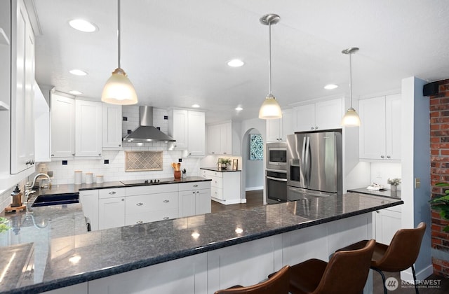 12043 184th Ave NE, Redmond, WA 98052 - kitchen featuring appliances with stainless steel finishes, wall chimney exhaust hood, decorative backsplash, a peninsula, and white cabinets