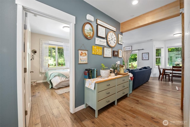 hall featuring light wood-type flooring, baseboards, and recessed lighting