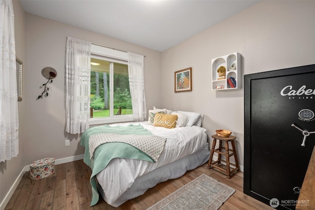bedroom featuring wood finished floors and baseboards