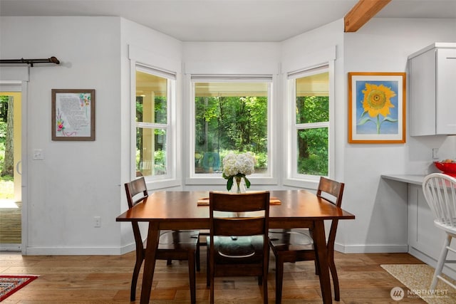 dining area with light wood-type flooring and baseboards