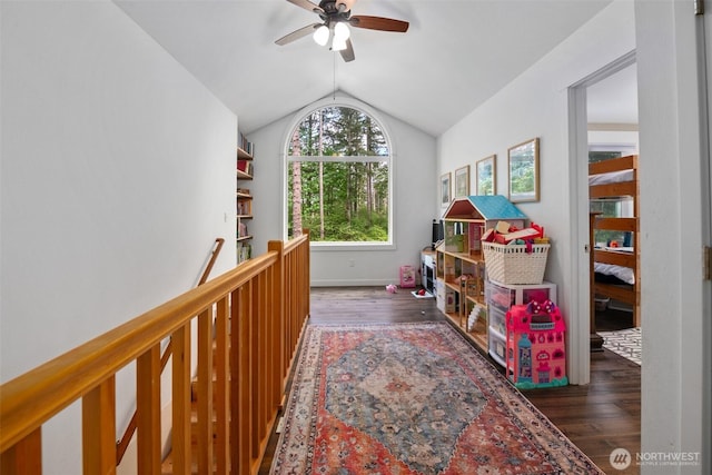 recreation room with wood finished floors, vaulted ceiling, a ceiling fan, and baseboards
