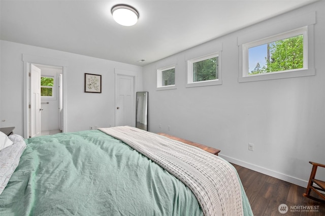 bedroom with dark wood-style floors and baseboards