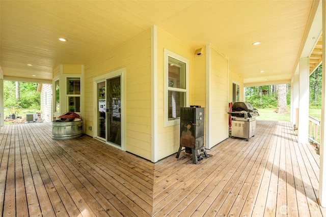 wooden terrace with cooling unit, area for grilling, and a porch