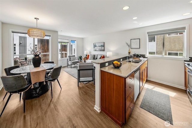 2432 Dexter Ave N Unit 201, Seattle, WA 98109 - kitchen with a sink, brown cabinets, light wood-style flooring, recessed lighting, and stainless steel dishwasher