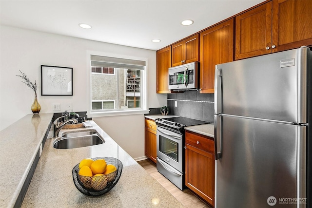 2432 Dexter Ave N Unit 201, Seattle, WA 98109 - kitchen with appliances with stainless steel finishes, a sink, tasteful backsplash, recessed lighting, and light countertops