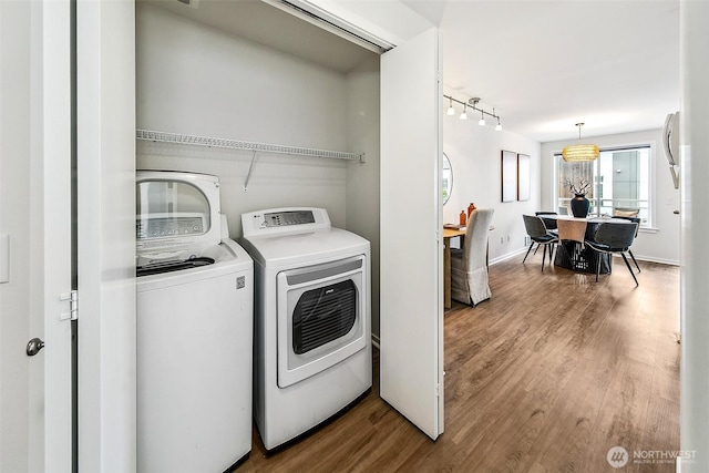 2432 Dexter Ave N Unit 201, Seattle, WA 98109 - laundry room with washer and clothes dryer, wood finished floors, rail lighting, and baseboards
