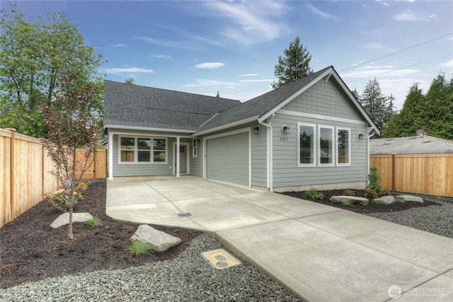 view of front of house with a garage, a shingled roof, driveway, and fence