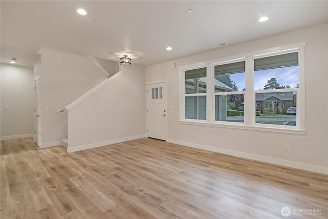 unfurnished living room featuring stairway, light wood-style floors, baseboards, and recessed lighting