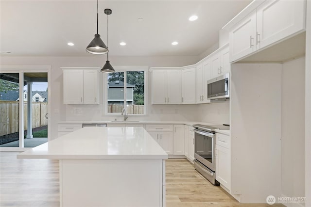 kitchen featuring stainless steel appliances, a sink, plenty of natural light, backsplash, and recessed lighting