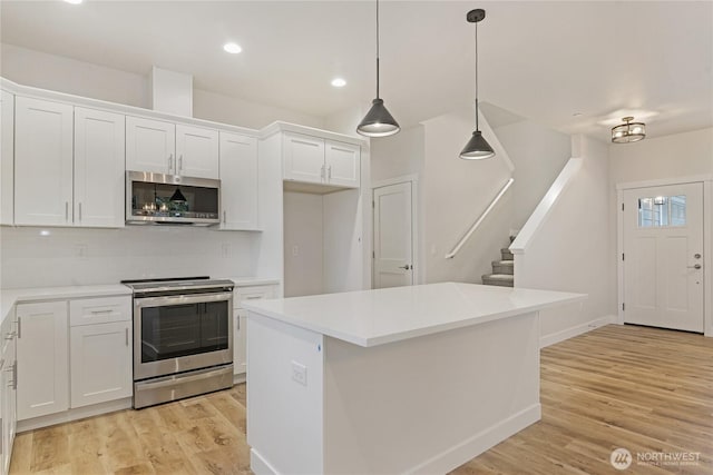 kitchen featuring appliances with stainless steel finishes, white cabinets, tasteful backsplash, light wood-style flooring, and recessed lighting