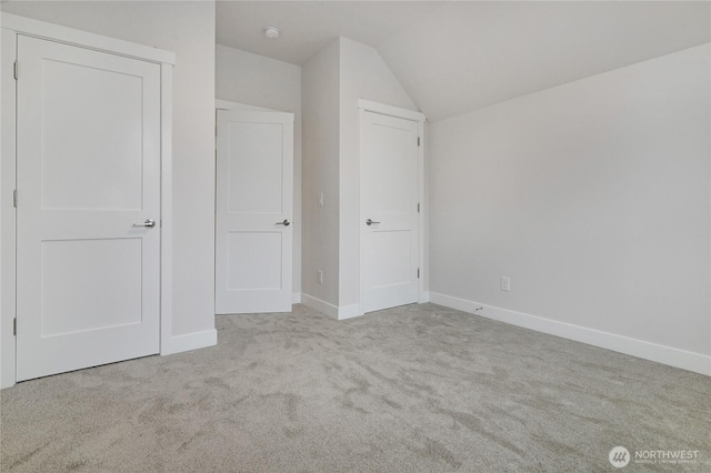 unfurnished bedroom with vaulted ceiling, carpet floors, and baseboards