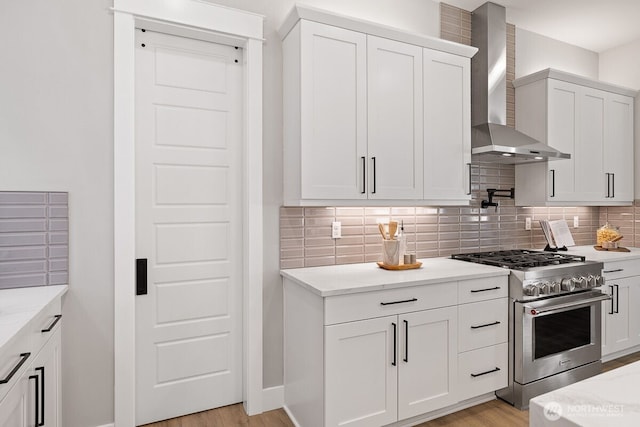 1428 238th St SE, Bothell, WA 98021 - kitchen with high end stainless steel range oven, wall chimney range hood, decorative backsplash, white cabinetry, and light wood-style floors