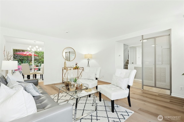 living room with wood finished floors, stairway, a chandelier, and baseboards