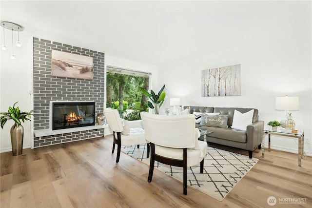 living room featuring wood finished floors, a fireplace, and baseboards