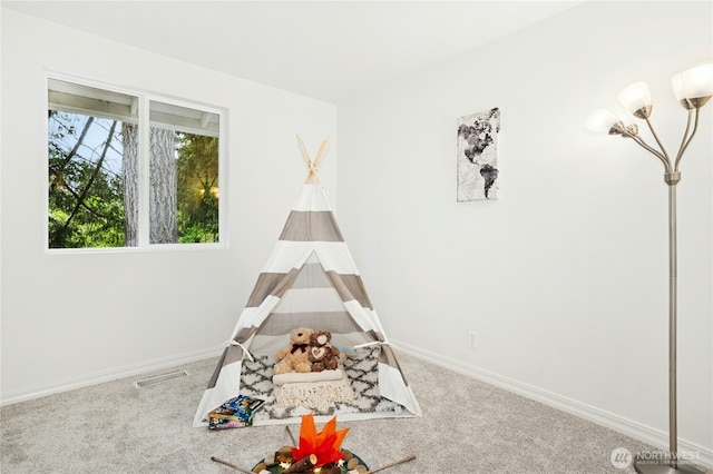 recreation room with baseboards and carpet