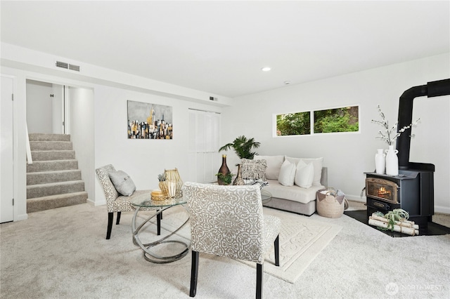 living area with a wood stove, stairway, carpet, and recessed lighting