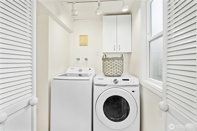 laundry room with cabinet space, washer and clothes dryer, and rail lighting