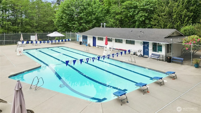 community pool with fence and a patio