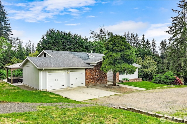 view of front facade featuring concrete driveway, a front lawn, a shingled roof, and a garage