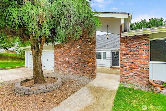 view of side of property featuring driveway, an attached garage, and brick siding