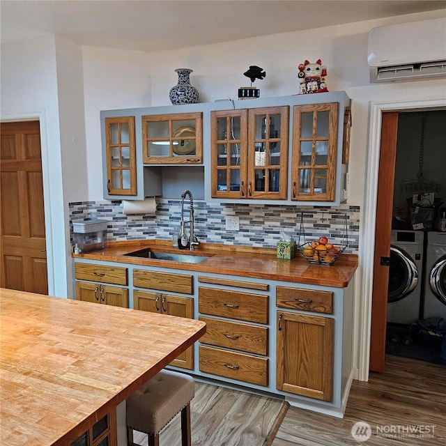 5830 115th Pl NE, Kirkland, WA 98033 - kitchen featuring wooden counters, washing machine and dryer, a sink, and a wall mounted air conditioner