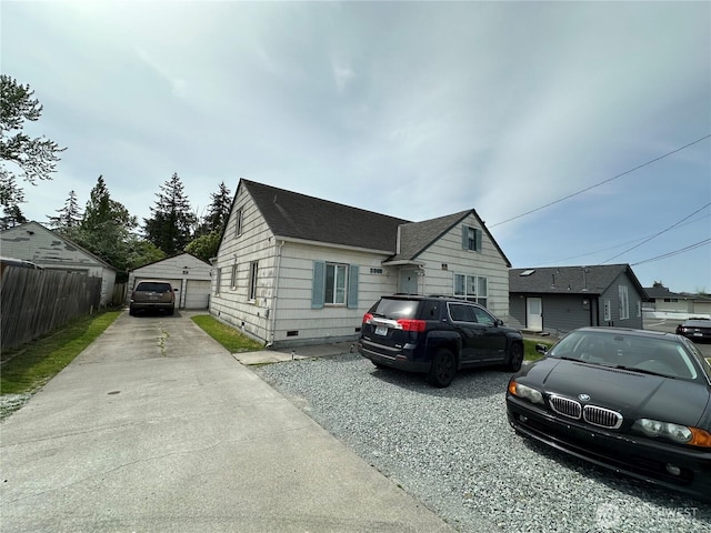 view of front of property with a detached garage, crawl space, fence, an outbuilding, and a shingled roof