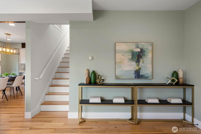 stairway with wood finished floors and baseboards