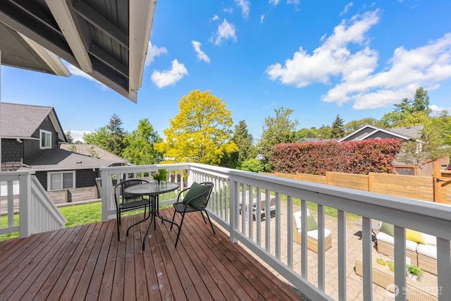 wooden terrace with outdoor dining area and fence