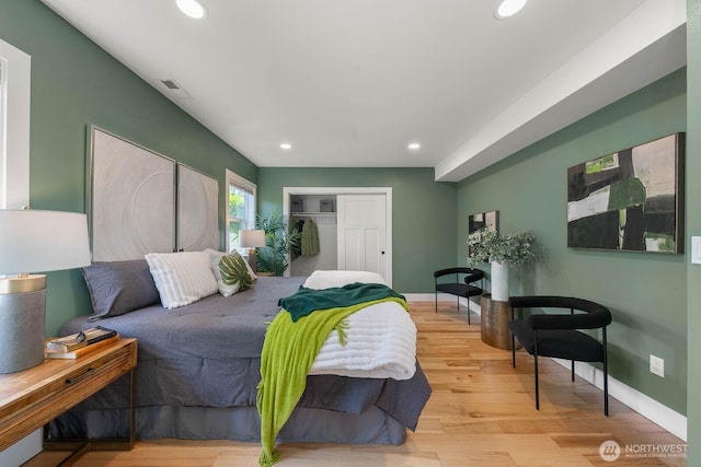 bedroom with a closet, recessed lighting, baseboards, and wood finished floors