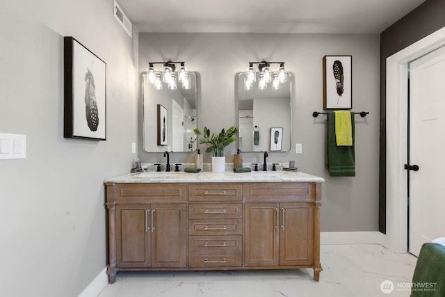 bathroom with marble look tiles, baseboards, and double vanity