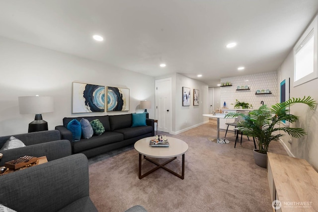 living area featuring light colored carpet, recessed lighting, and baseboards