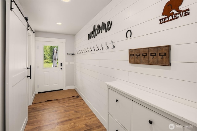 12915 212th St SE, Snohomish, WA 98296 - entryway with a barn door, baseboards, light wood finished floors, recessed lighting, and wooden walls