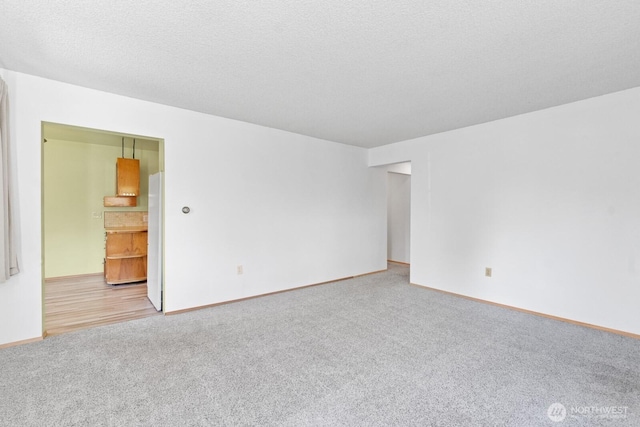carpeted empty room with baseboards
