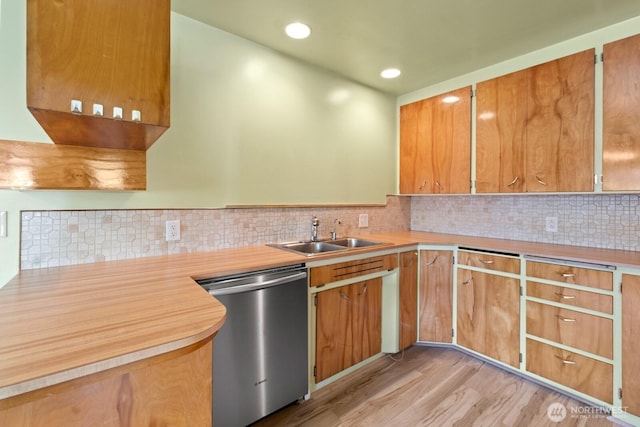 kitchen featuring dishwasher, a sink, recessed lighting, light countertops, and light wood-style floors