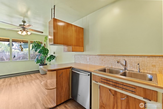 kitchen with stainless steel dishwasher, a sink, light countertops, decorative backsplash, and a ceiling fan
